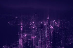 A vibrant night view of a city skyline illuminated in shades of purple.