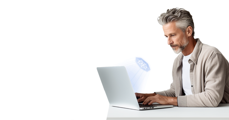 A man with gray hair working on a laptop,focused on the screen.